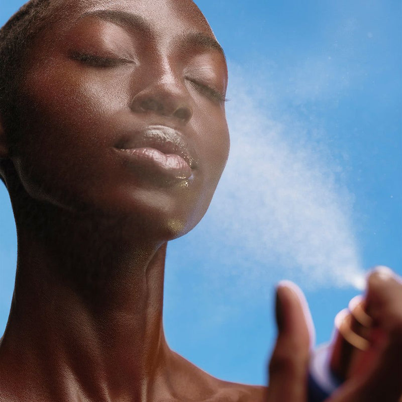 Girl spraying her face with mist