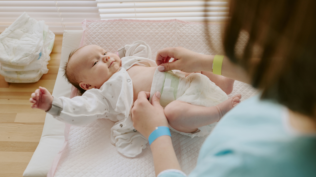 Mother changing baby diaper