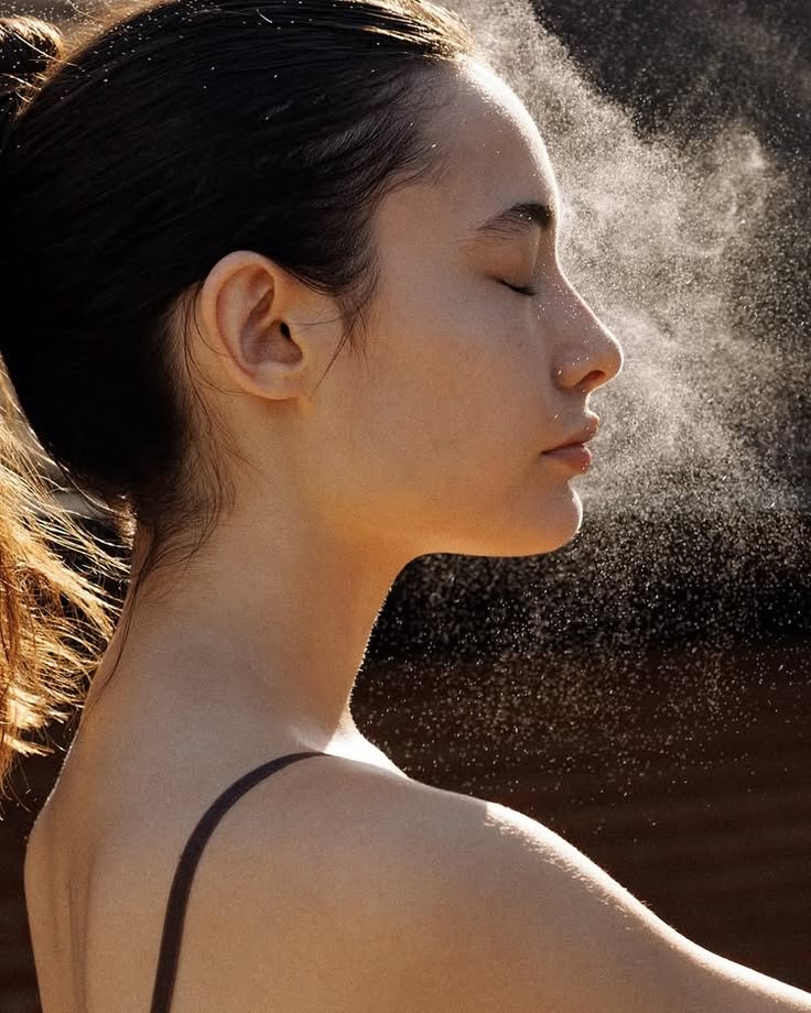Girl spraying her face with mist